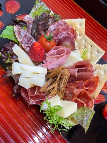 un plato de comida con queso y otros alimentos en Okiya Guest House & Tapas Bar, en Kiryu