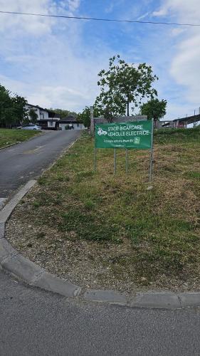 a green sign on the side of a road at Hanu lu Mos Opinca in Deva