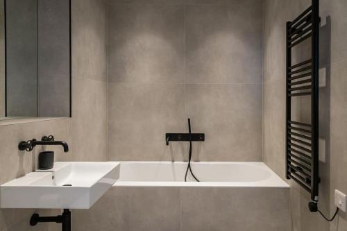 a bathroom with a sink and a bath tub at Amazing Seaview - 2 bedroom, 2 bathroom in St. Leonards