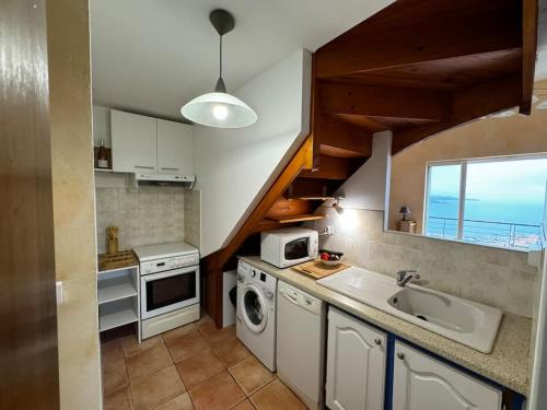 une cuisine avec un évier et une machine à laver dans l'établissement T4 en duplex, vue mer et piscine, à Banyuls-sur-Mer