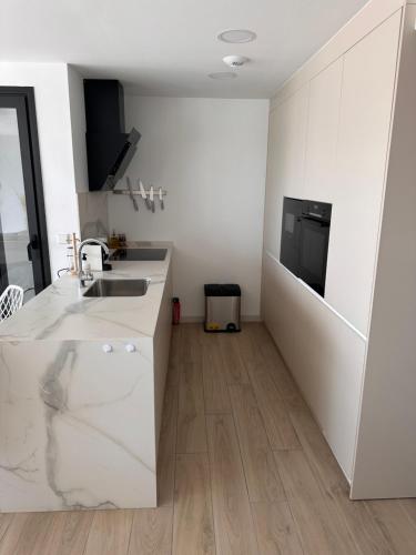 La cuisine blanche est équipée d'un évier et d'un réfrigérateur. dans l'établissement MADRESELVA 62.29, à Torre-Pacheco