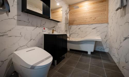 a bathroom with a toilet and a sink and a tub at CM Park Hotel in Andong