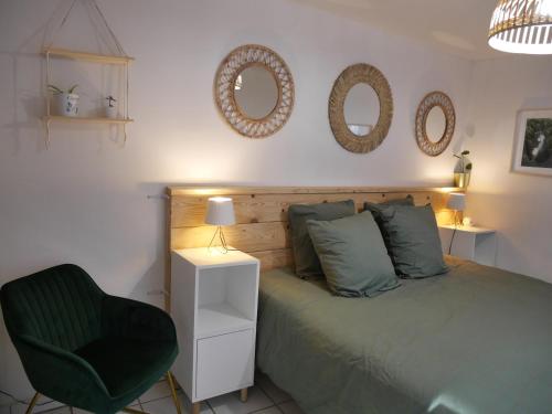 a bedroom with a bed and a chair and mirrors at La maison aux bambous in Montreuil