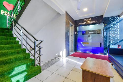 a lobby with a staircase and green carpet at Hotel Avadh Palace, Subhash Bridge, RTO Circle, Ahmedabad in Ahmedabad