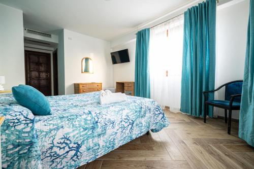 a bedroom with a bed with a blue comforter at La Rosa Hotel - Selinunte in Marinella di Selinunte