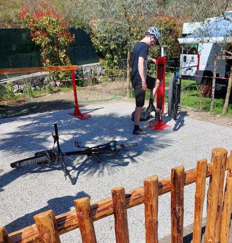 a man standing next to a bike laying on the ground at Agricampeggio Paolino in Pietramurata