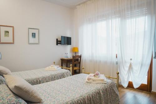 1 dormitorio con 2 camas y ventana en Lucignolo, en Fucecchio