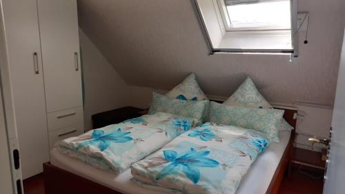 a small bedroom with a bed with blue flowers at Ferienhaus Berndt im Spreewald in Lübbenau