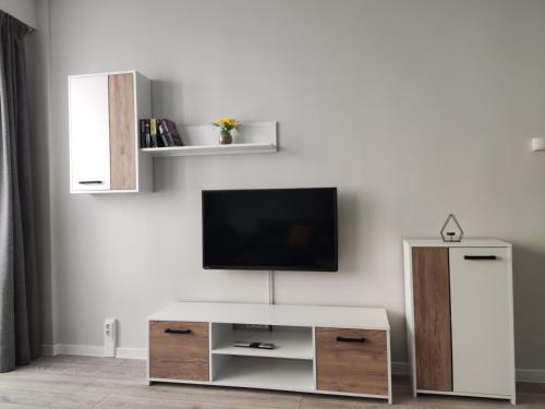 a living room with a tv on a white wall at Maya's Airport Apartment in Sofia