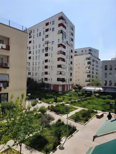 um grande edifício de apartamentos com um parque em frente em Tirana Guest Apartment em Tirana