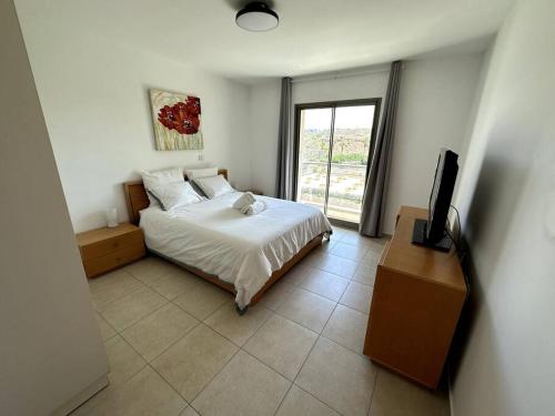 a bedroom with a bed and a television in it at Elegant 1 Bedroom Oasis Marina in Herzelia 