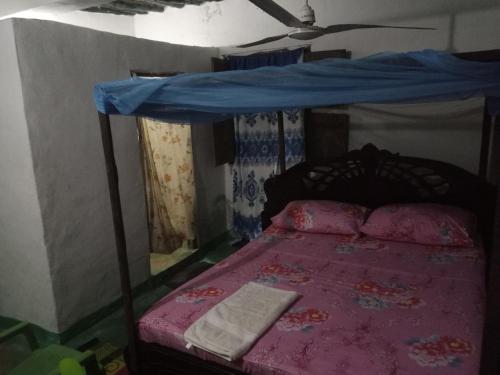 - une chambre avec un lit à baldaquin bleu dans l'établissement Tabassam Guest House, à Lamu
