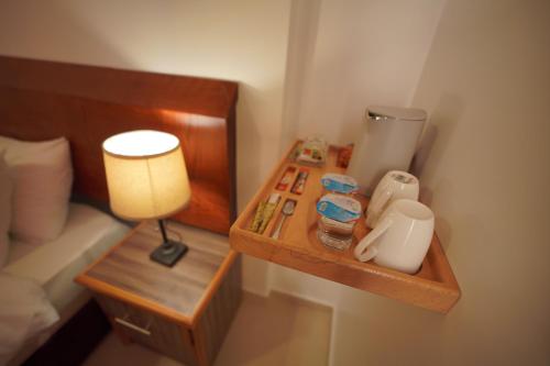 a bed room with a nightstand with a lamp and a table at Petra Plaza Hotel in Wadi Musa