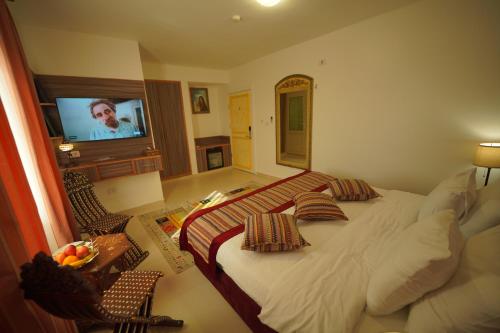 a bedroom with a large bed and a flat screen tv at Petra Plaza Hotel in Wadi Musa