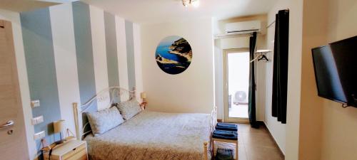 - une petite chambre avec un lit et une télévision dans l'établissement Ai Laghi Bed&Bed, à Messina