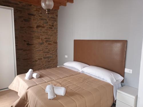 a bedroom with a large bed with towels on it at Apartamento Café Teatro in Arzúa