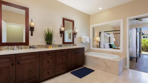 a bathroom with two sinks and a bath tub and a tubermott at HOUSE OF MANTA Light and Airy Access to Private Beach Club in Waikoloa