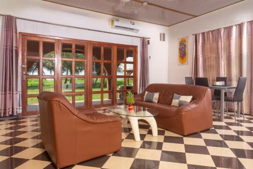 a living room with two couches and a table at Mekandi Riverside Resort in Akuse