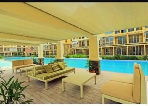 een patio met banken en een zwembad in een gebouw bij Amalfi Oasis SRP in Cebu City