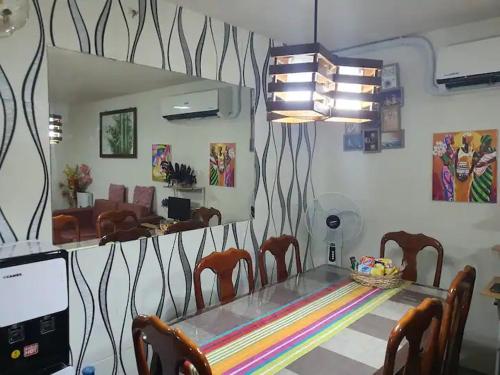 een eetkamer met een tafel en stoelen en een spiegel bij Amalfi Oasis SRP in Cebu City