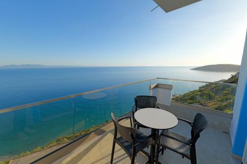 a balcony with a table and chairs and the ocean at Vila Bana in Qeparo