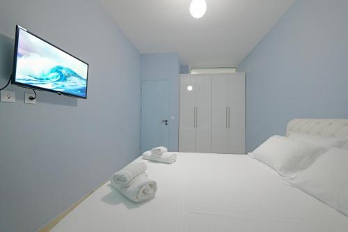 a white room with a bed and a flat screen tv at Vila Bana in Qeparo