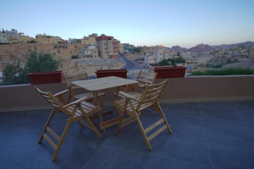 einen Tisch und Stühle auf einem Balkon mit Aussicht in der Unterkunft Petra Plaza Hotel in Wadi Musa