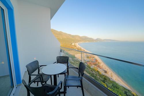 a balcony with chairs and a table and the ocean at Vila Bana in Qeparo