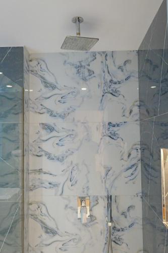 a bathroom with a blue and white marble wall at Vila Bana in Qeparo