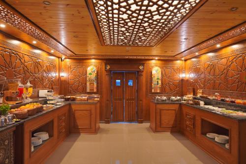 a kitchen with wooden walls and a ceiling with lights at Petra Plaza Hotel in Wadi Musa