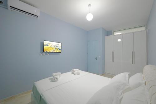 a bedroom with a white bed and a window at Vila Bana in Qeparo