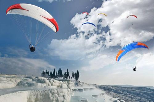 a group of people riding parachutes in the sky at Olive Hotel in Pamukkale