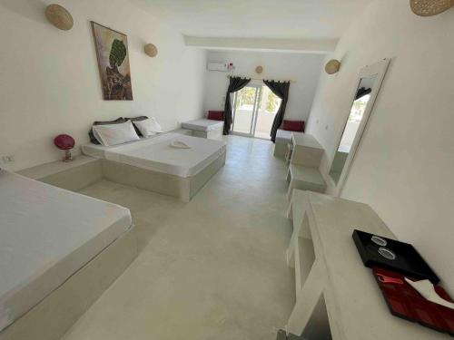 a white room with a bed and a staircase at Ascot Watamu in Watamu