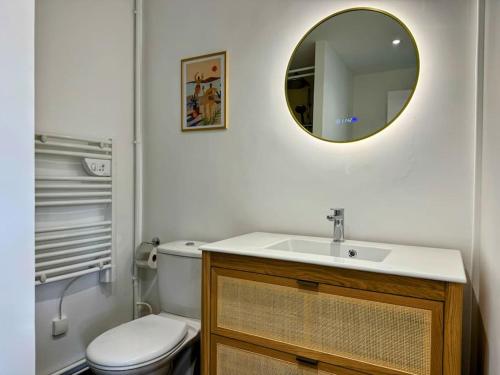 une salle de bain avec un lavabo, des toilettes et un miroir dans l'établissement Le Logis du Roi, Hyper centre-ville, à Amiens