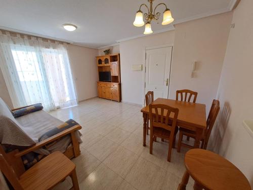 cocina y comedor con mesa y sillas en Apartamentos Las Palmeras V.v. en La Manga del Mar Menor