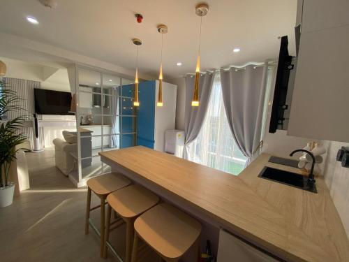 a kitchen with a counter and stools in a room at Muji Inspired Beach view in San Fernando