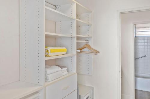 a walk in closet with white shelves and towels at Brand New Condo with excellent reviews in Kahana