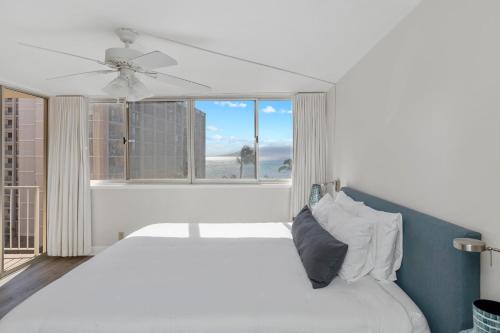 a bedroom with a white bed and a window at Brand New Condo with excellent reviews in Kahana