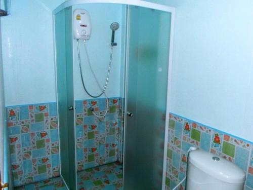 a bathroom with a shower and a toilet in it at Suksomjai Hotel in Rayong