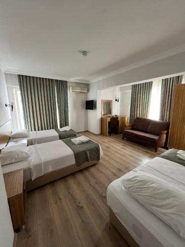 a hotel room with two beds and a couch at Mert Seaside Hotel in Marmaris