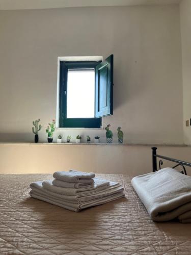 einen Stapel Handtücher auf dem Bett in der Unterkunft Vista da Re in Aci Castello
