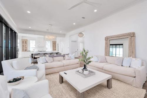 a living room with white furniture and a piano at Somewhere With You in Inlet Beach