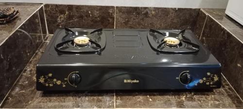 a black stove top oven sitting on top of a counter at Mutiara Homestay Jogja in Ngingas