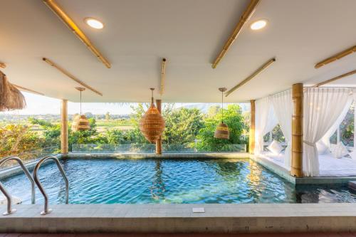 a swimming pool in a house with a large window at Pupah Kanna Pua-ปู๋ ป๋าล์ คันนา ปัว in Pua