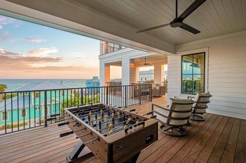 a screened in porch with a foosball table and chairs at Somewhere With You in Inlet Beach