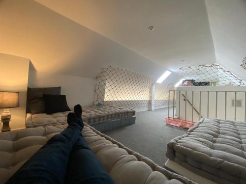 a person laying on a couch in a living room at B&B - Villa des Remparts - Ardres proche Calais-St Omer-Dunkerque in Ardres