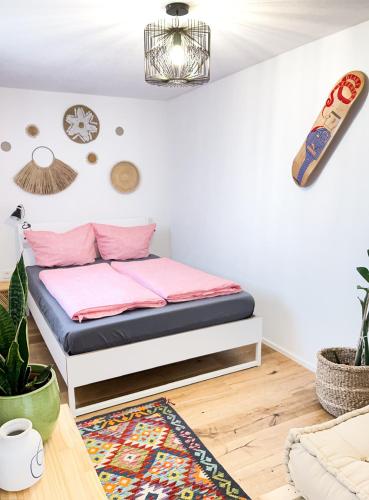 a bedroom with a bed with pink sheets at Hacienda Rooms in Friedrichshafen