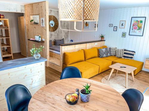 ein Wohnzimmer mit einem gelben Sofa und einem Tisch in der Unterkunft Hacienda Hotel in Friedrichshafen