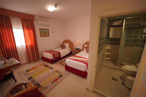 a hotel room with two beds and a shower at Petra Plaza Hotel in Wadi Musa