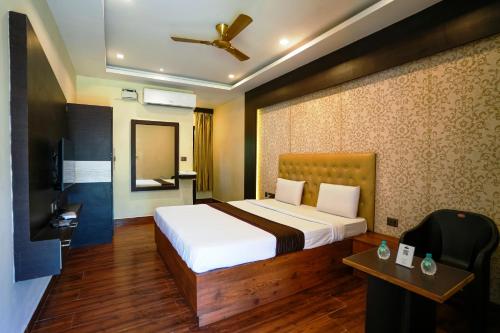 um quarto de hotel com uma cama e uma televisão em La Courtyard em Pondicherry